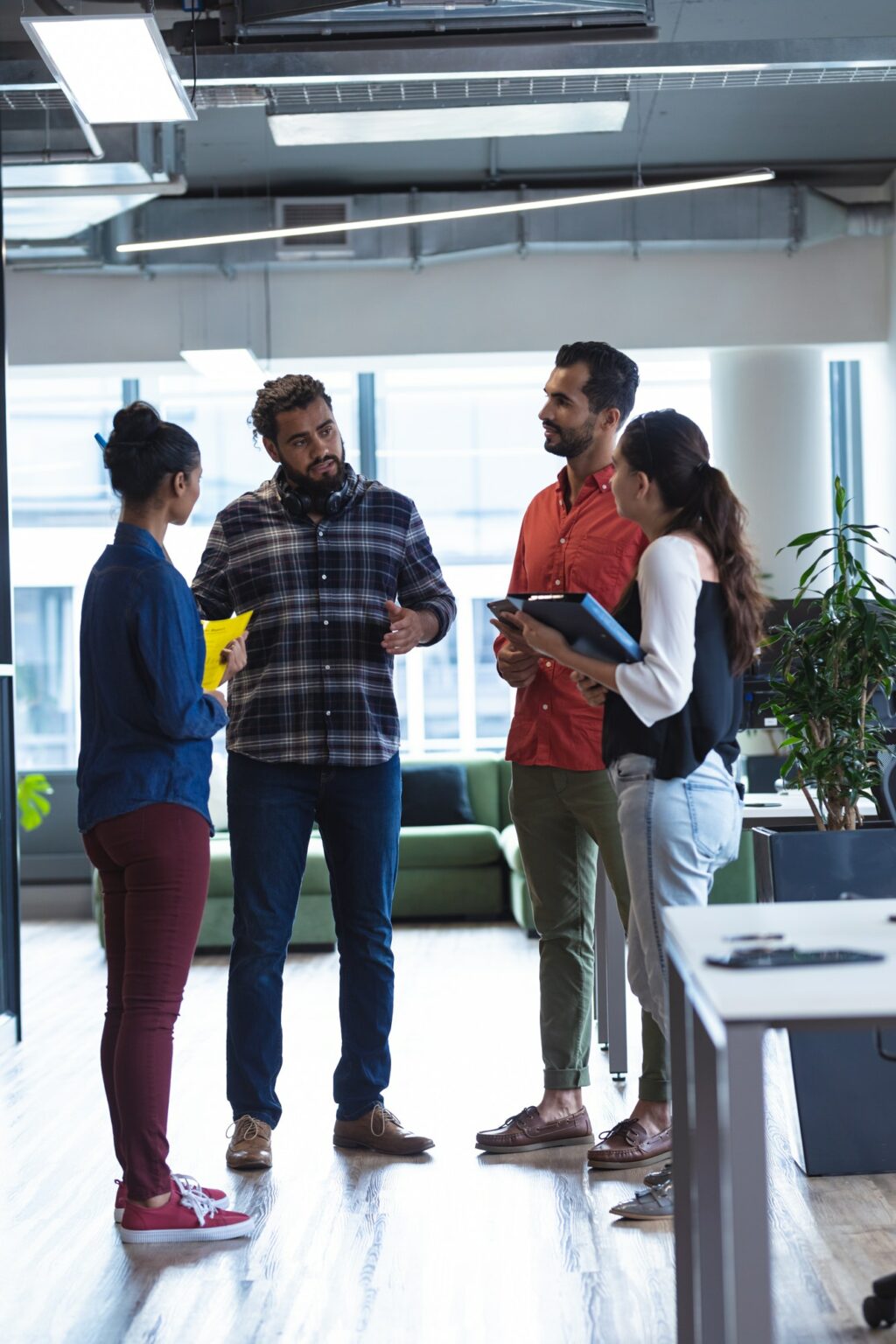 Diverse group of creative colleagues talking at casual meeting